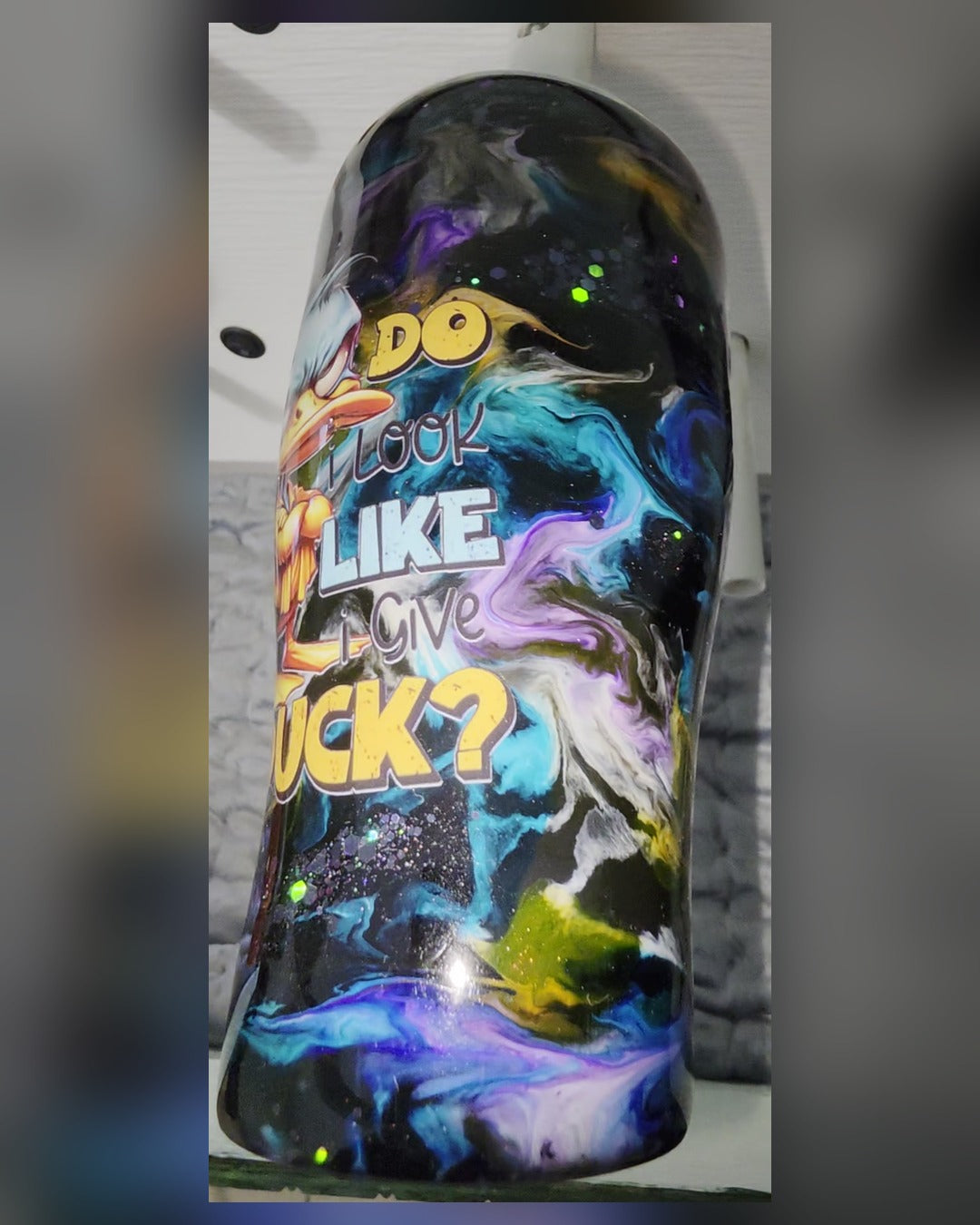 Side view of duck tumbler with colorful epoxy swirls and glitter